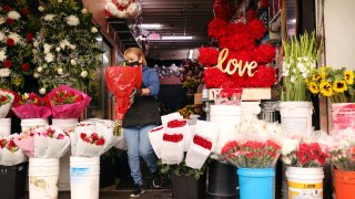 Adriana Gamez restocks rose bouquets at California Flowers in downtown Los Angeles on Feb. 12, 2021.