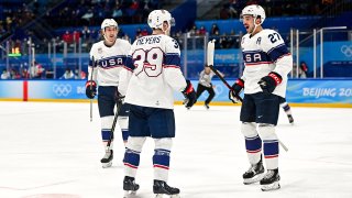 Ben Meyers (#39) celebrates with his USA teammates after scoring a goal against Canada in a preliminary round game at the 2022 Winter Olympics.