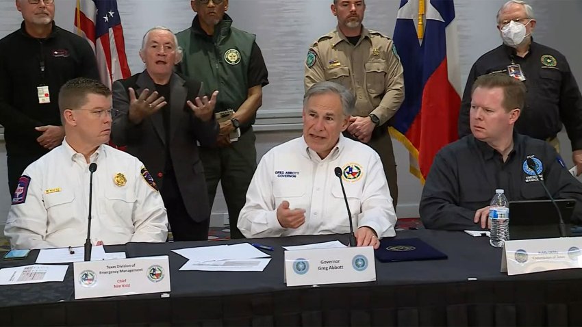 Gov. Greg Abbott, center, delivers an update on a winter storm in Texas, Feb. 3, 2022.