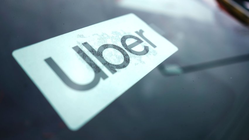 FILE – An Uber sign is displayed inside a car in Palatine, Ill., Thursday, Feb. 10, 2022. Citing record-high prices for gasoline, Uber is charging customers a new fuel fee to help offset costs for ride-hail and delivery drivers. The company announced Friday, March 11, 2022, that the temporary surcharge will be either 45 cents or 55 cents for each Uber trip and either 35 cents or 45 cents for each Uber Eats order, depending on location.