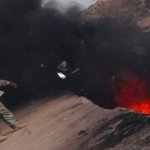 A soldier tosses unserviceable uniforms into a burn pit in Iraq on March 10, 2008.