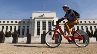 A cyclist passes the Federal Reserve headquarters in Washington.