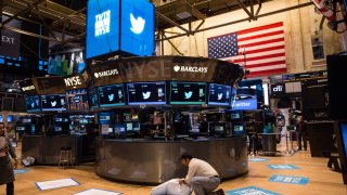 A worker unveils a floor mat bearing the logo of Twitter and the symbol on which Twitter’s stock will traded (TWTR) on the floor of the New York Stock Exchange (NYSE) on November 7, 2013 in New York City.