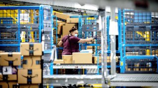 A worker sorts out parcels in the outbound dock at Amazon fulfillment center in Eastvale, California on Tuesday, Aug. 31, 2021.