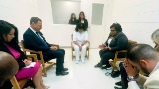 In this April 6, 2022 photo provided by Texas state Rep. Jeff Leach, Texas death row inmate Melissa Lucio, dressed in white, leads a group of seven Texas lawmakers in prayer in a room at the Mountain View Unit in Gatesville, Texas.
