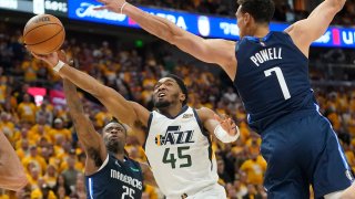 Utah Jazz guard Donovan Mitchell (45) goes to the basket as Dallas Mavericks’ Reggie Bullock (25) and Dwight Powell (7) defend in the second half of Game 4 of an NBA basketball first-round playoff series, Saturday, April 23, 2022, in Salt Lake City.