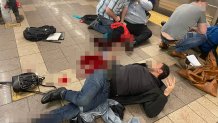 Injured subway riders seen on the platform of the 36th Street station in Brooklyn's Sunset Park neighborhood in New York, April 12, 2022. At least five people have been shot by a man in a gas mask and orange construction vest, according to the NYPD.