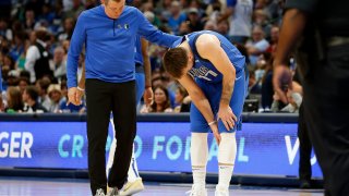 Luka Doncic #77 of the Dallas Mavericks is attended to my Casey Smith head trainer in the second half against the San Antonio Spurs at American Airlines Center on April 10, 2022 in Dallas, Texas.