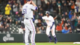 Spencer Patton #61 of the Texas Rangers reacts after giving up a two-run home run to Abraham Toro #13 of the Seattle Mariners during the seventh inning at T-Mobile Park on April 19, 2022 in Seattle, Washington.