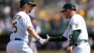 Stephen Piscotty #25 of the Oakland Athletics is congratulated by third base coach Darren Bush #51 on his two-run home run against the Texas Rangers in the bottom of the fourth inning at RingCentral Coliseum on April 24, 2022 in Oakland, California. (Photo by Thearon W. Henderson/Getty Images)