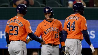 Yordan Alvarez #44 of the Houston Astros and Michael Brantley #23 of the Houston Astros celebrate with Aledmys Diaz #16 of the Houston Astros after scoring against the Texas Rangers on a two-run double hit by Kyle Tucker #30 of the Houston Astros in the top of the fifth inning at Globe Life Field on April 27, 2022 in Arlington, Texas.