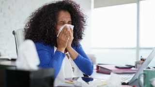 person sneezing while in an office