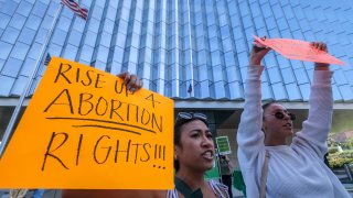 Demonstrators holding signs protest outside of the U.S. Courthouse in response to a leaked draft of the Supreme Court's opinion to overturn Roe v. Wade