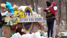 FILE - Students hug at a memorial at Oxford High School in Oxford, Mich., Dec. 1, 2021. Authorities say a 15-year-old sophomore opened fire at Oxford High School, killing four students and wounding seven other people Nov. 30, 2021. The May 2022 shooting rampage in a Buffalo supermarket, carried out by an 18-year-old who was flagged for making a threatening comment at his high school the year before, highlights concerns over whether schools are adequately supporting and screening students. 