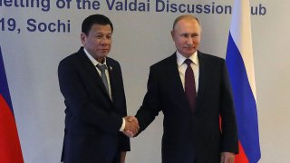 Russian President Vladimir Putin (R) shakes hands with Philippine's President Rodrigo Duterte