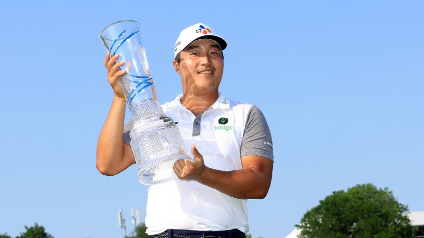 K.H. Lee of South Korea poses with the trophy after winning on the 18th green during the final round of the AT&T Byron Nelson at TPC Craig Ranch on May 15, 2022 in McKinney, Texas.