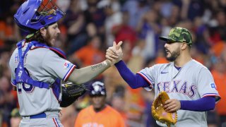 Jonah Heim #28 of the Texas Rangers and Martin Perez #54 of the Texas Rangers celebrate defeating the Houston Astros 3-0 at Minute Maid Park on May 20, 2022 in Houston, Texas.