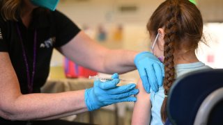 A nurse administers a pediatric dose of the Covid-19 vaccine to a girl at a L.A. Care Health Plan vaccination clinic at Los Angeles Mission College in the Sylmar neighborhood in Los Angeles, California, January 19, 2022.