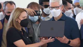 Apple CEO Tim Cook (R) looks at a newly redesigned MacBook Air laptop during the WWDC22 at Apple Park on June 06, 2022 in Cupertino, California. Apple CEO Tim Cook kicked off the annual WWDC22 developer conference.