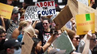 Abortion rights activists hoist their signs outside the US Supreme Court in Washington, DC, on June 24, 2022.