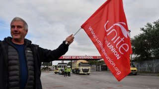 A striking dockworker on a picket line outside the Port of Liverpool during a strike in Liverpool, UK, on Tuesday, Sept. 20, 2022. Dockers at Britains fourth-biggest container port voted unanimously to reject their employers latest pay offer — and walk off the job for two weeks in a strike that gets into full swing on Tuesday. Photographer: Anthony Devlin/Bloomberg via Getty Images