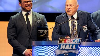 FILE - Hall of Fame inductee Bruton Smith entertains the crowd as his son, Marcus Smith, left, looks on during NASCAR Hall of Fame Induction ceremonies in Charlotte, N.C., in this Saturday, Jan. 23, 2016, file photo.