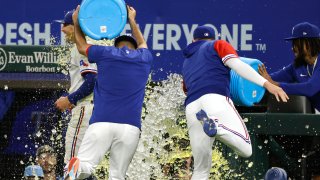 Brad Miller #13 of the Texas Rangers is doused with Powerade by teammates following the teams 5-3 win over the Houston Astros at Globe Life Field on June 13, 2022 in Arlington, Texas.