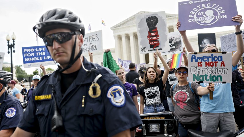 Anti-abortion rights and abortion rights demonstrators hold signs outside the US Supreme Court in Washington, D.C., US, on Friday, June 24, 2022. A deeply divided Supreme Court overturned the 1973 Roe v. Wade decision and wiped out the constitutional right to abortion, issuing a historic ruling likely to render the procedure largely illegal in half the country.