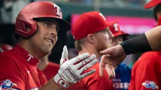 ARLINGTON, TEXAS – AUGUST 26: Nathaniel Lowe #30 of the Texas Rangers high fives teammates after hitting a solo homer against the Detroit Tigers at Globe Life Field on August 26, 2022 in Arlington, Texas.