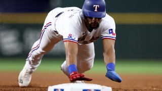 Leody Taveras #3 of the Texas Rangers dives back to first base to beat the throw from Adam Oller #36 of the Oakland Athletics in the bottom of the second inning at Globe Life Field on August 17, 2022 in Arlington, Texas.