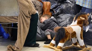 FILE - An evacuated girl from Afghanistan takes a nap in a temporary check-in hall and waits for a plane that will take her to Dallas in the United States at Ramstein Air Base on Aug. 26, 2021, in Ramstein-Miesenbach, Germany.