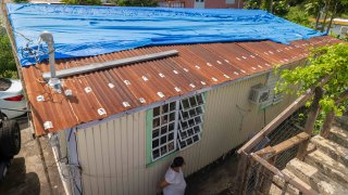 Virmisa Rivera stands outside or home damaged by Hurricane Maria nearly five years ago, in Loiza, Puerto Rico, Thursday, Sept. 15, 2022.