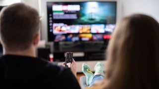 A couple sits in front of the television