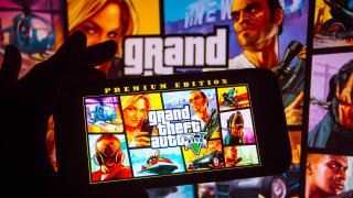 In this photo illustration the Grand Theft Auto (GTA) logo is seen displayed on a smartphone.
