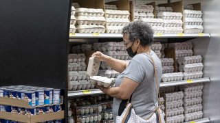 A shopper checks a carton of eggs at a San Francisco grocery store on May 2, 2022.