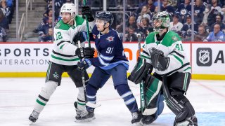 Radek Faksa #12 of the Dallas Stars and Cole Perfetti #91 of the Winnipeg Jets battle in front of goaltender Scott Wedgewood #41 as they keep an eye on the play during third period action at the Canada Life Centre on November 8, 2022 in Winnipeg, Manitoba, Canada.