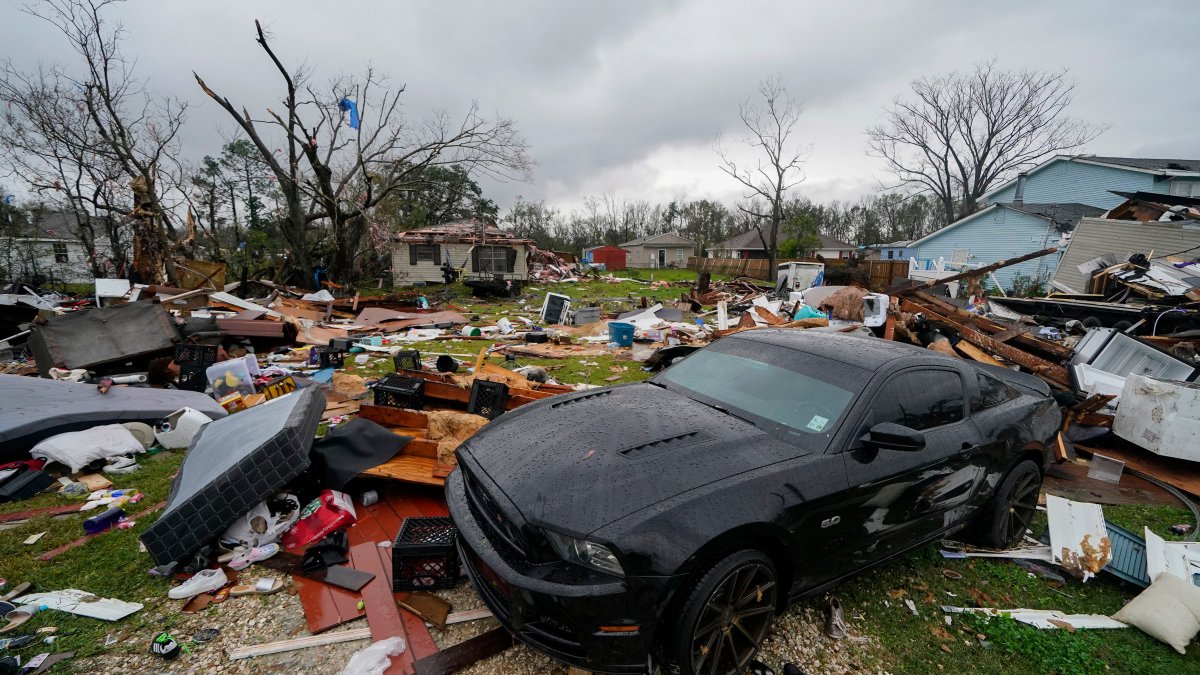 A house and car are seen damaged after a confirmed tornado on Friscoville Avenue in Arabi, La., in St. Bernard Parish, Wednesday, Dec. 14, 2022.