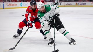 Luke Glendening #11 of the Dallas Stars skates with the puck as Erik Gustafsson #56 of the Washington Capitals defends during the third period of the game at Capital One Arena on December 15, 2022 in Washington, DC.