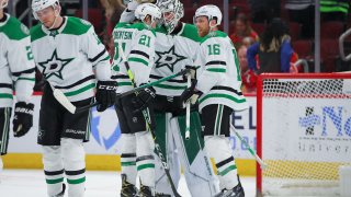 Dallas Stars left wing Jason Robertson (21) and Dallas Stars center Joe Pavelski (16) celebrate with Dallas Stars goaltender Jake Oettinger (29) after a game between the Dallas Stars and the Chicago Blackhawks on April 10, 2022 at the United Center in Chicago, IL.