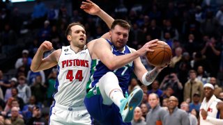 Luka Doncic #77 of the Dallas Mavericks pulls down a rebound agaiinst Bojan Bogdanovic #44 of the Detroit Pistons late in the second half at American Airlines Center on January 30, 2023 in Dallas, Texas. The Mavericks won 111-105.