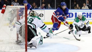 Mika Zibanejad #93 of the New York Rangers takes a shot on goal as Miro Heiskanen #4 and Jake Oettinger #29 of the Dallas Stars defend during overtime at Madison Square Garden on January 12, 2023 in New York City. The Rangers won 2-1 in overtime.