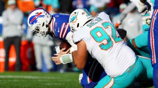 Zach Sieler #92 of the Miami Dolphins tackles Josh Allen #17 of the Buffalo Bills during the second quarter of the game in the AFC Wild Card playoff game at Highmark Stadium on January 15, 2023 in Orchard Park, New York.