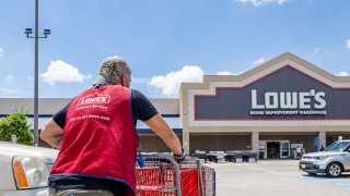 A Lowe’s Home Improvement Warehouse worker collects carts in a parking lot on August 17, 2022 in Houston, Texas.