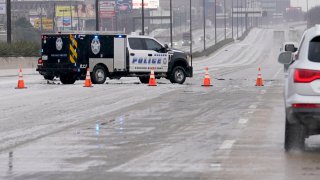 A City of Dallas emergency vehicle blocks lanes of U.S. Highway 75 during icy and slushy road conditions, Wednesday, Feb. 1, 2023, in Dallas.