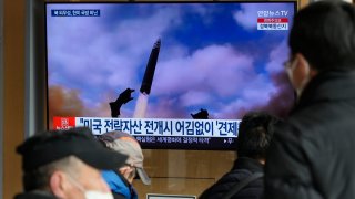 FILE - A TV screen shows a file image of North Korea's missile launch