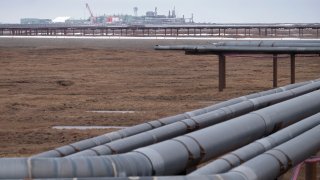 FILE - Oil pipelines stretch across the landscape outside Nuiqsut, AK