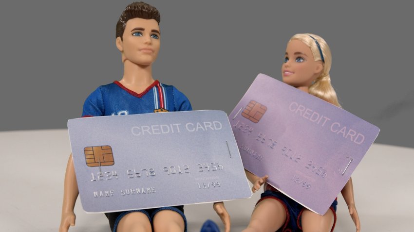 A Barbie and Ken doll holding Credit cards.