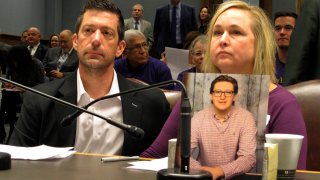 Stephen and Rae Ann Gruver sit in a House committee room behind a photo of their son, 18-year-old Maxwell Gruver, a Louisiana State University freshman who died with a blood-alcohol content six times higher than the legal limit for driving in what authorities say was a hazing incident, in Baton Rouge, La