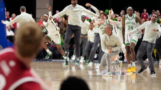 North Texas players and coaches celebrate after defeating Wisconsin in an NCAA college basketball game in the semifinals of the NIT, Tuesday, March 28, 2023, in Las Vegas.