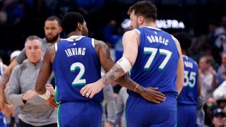 Kyrie Irving #2 and teammate Luka Doncic #77 of the Dallas Mavericks celebrate against the Philadelphia 76ers in the second half at American Airlines Center on March 2, 2023 in Dallas, Texas. The Mavericks won 133-126.